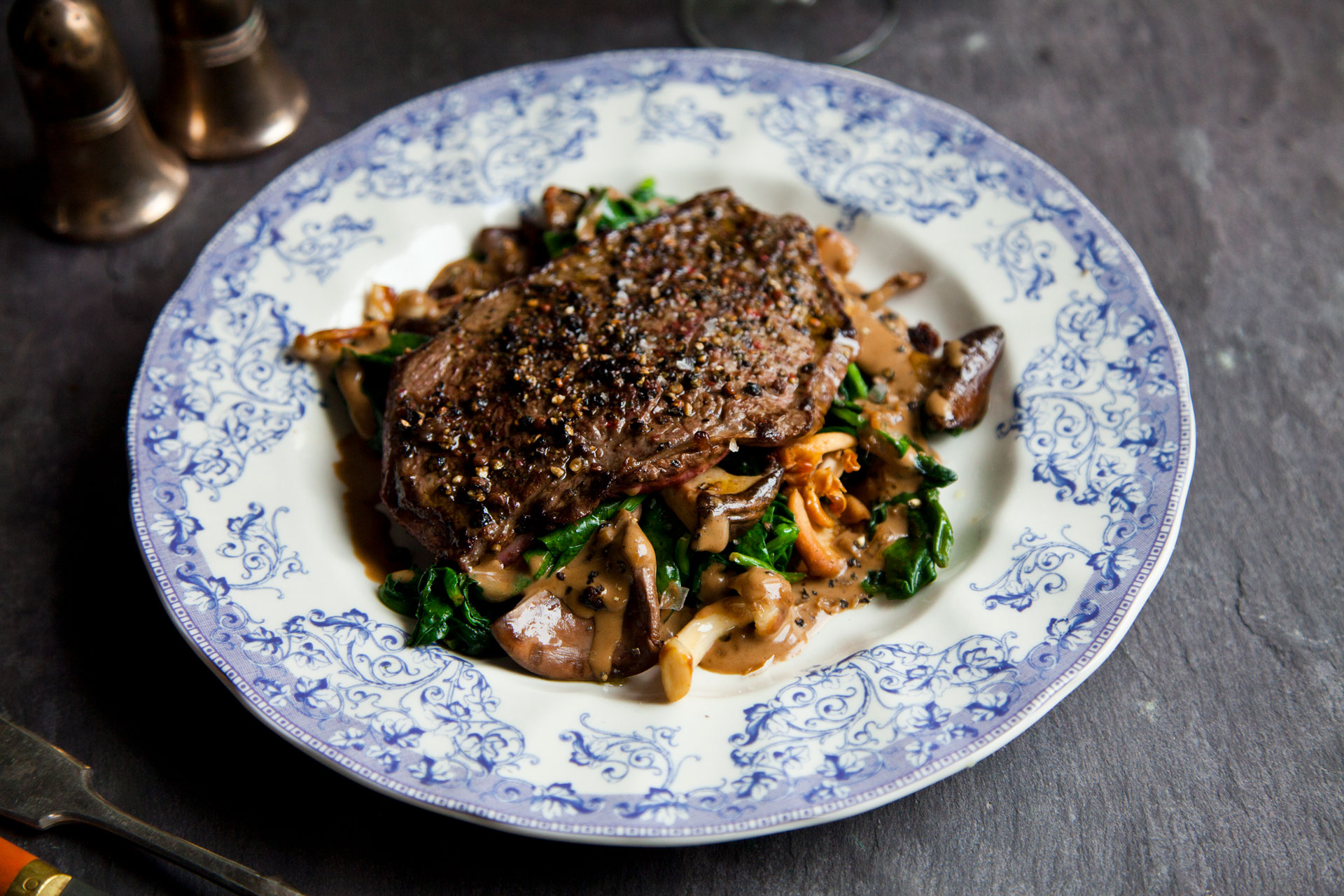 Medaglioni di manzo ai grani di pepe con spinaci e funghi di bosco