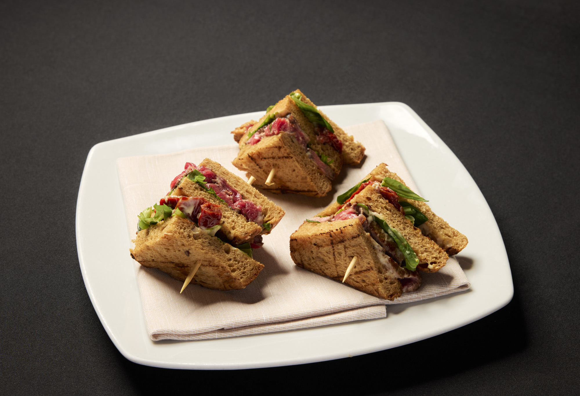 Sandwich di manzo irlandese con pomodori secchi, mayo di senape e miele e rucola e valeriana